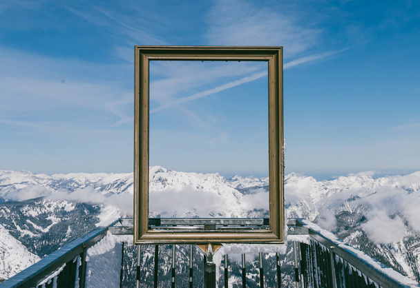 Spectacular view of clear sky and snowy mountain peaks through golden picture frame in Austrian Alps. View from Five Fingers, Obertraun - Фото, зображення