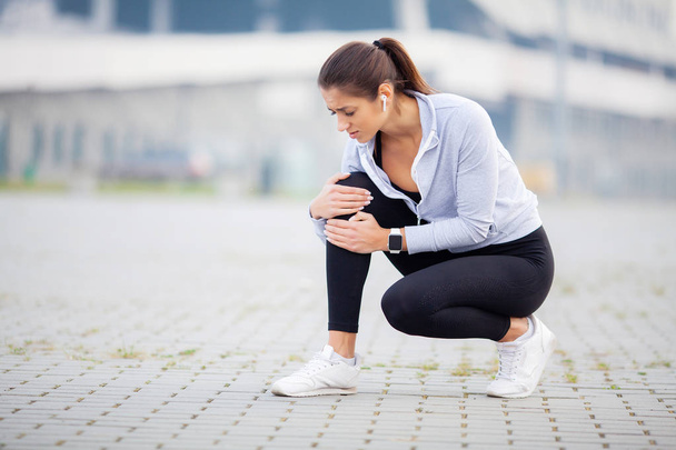 Fitness. Athletic women holding knee having a trauma - Photo, Image