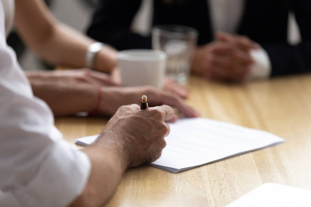 Close up hands of businesspeople sitting at desk signing agreeme - Foto, Bild