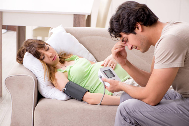 A férj ellenőrzi a terhes feleségek vérnyomását - Fotó, kép