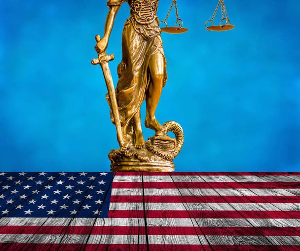 Άγαλμα της δικαιοσύνης στο ξύλινο πάτωμα με Ηνωμένες Πολιτείες σημαία και γαλάζιο φόντο του ουρανού - Φωτογραφία, εικόνα