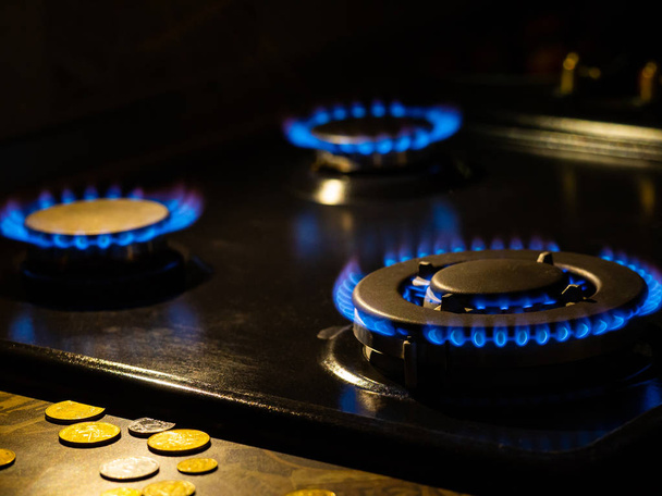 Quema de gas, estufa de gas quemador con monedas en el suelo, vitrocerámica en la cocina
 - Foto, imagen