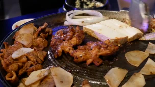 Moción de camarera cocinando carne de barbacoa para el cliente en la mesa dentro del restaurante coreano
  - Imágenes, Vídeo