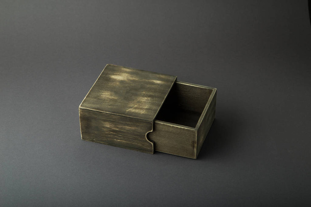 Drewniane pudełko, opakowanie na prezent, na ciemnym tle. - Zdjęcie, obraz