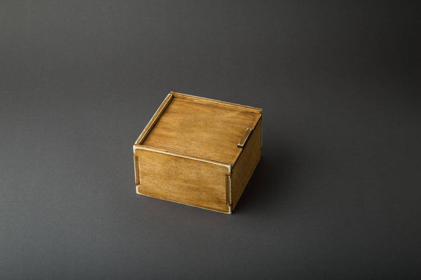 Caja de madera, envoltura de regalo, sobre un fondo oscuro
. - Foto, Imagen