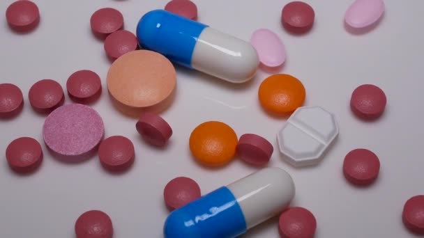 Pillereiden ja tablettien kiertäminen valkoisella taustalla
  - Materiaali, video