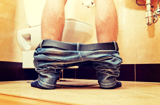 Man peeing in toilet at home - 写真・画像