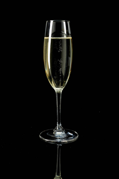 glass with white sparkling wine champagne against a dark background - Foto, imagen
