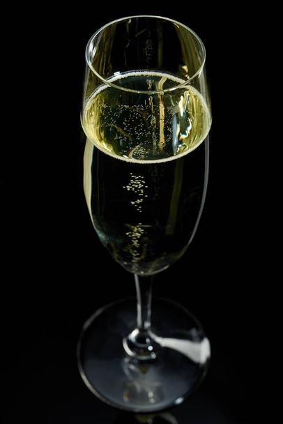 glass with white sparkling wine champagne against a dark background - Fotoğraf, Görsel