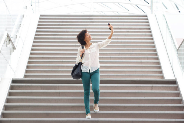 Portrait de femme heureuse prenant selfie par des escaliers
 - Photo, image