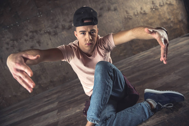 Young man break dancing on the wall background, performing tricks - 写真・画像
