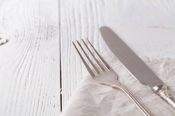 Knife, fork with linen serviette on the white background - Fotoğraf, Görsel