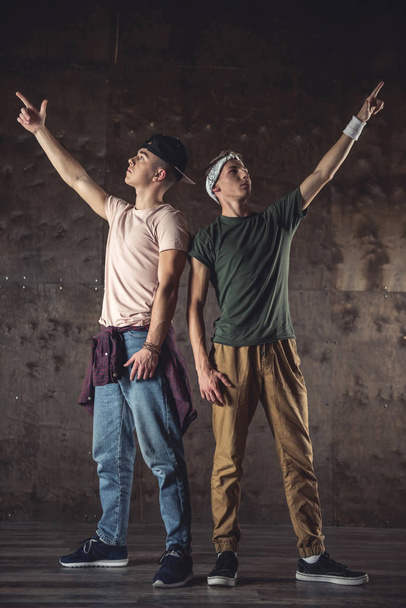 Young men break dancing on the wall background, performing tricks - Foto, Imagen