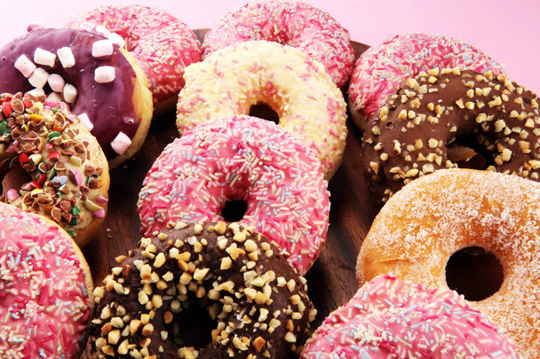 erilaisia donitseja suklaa himmeä, vaaleanpunainen lasitettu ja sprinkles donitseja. - Valokuva, kuva