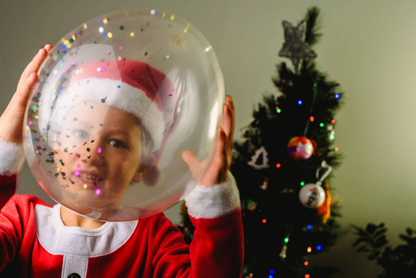 Porträt des blonden und gutaussehenden 5-jährigen Jungen als Weihnachtsmann in  - Foto, Bild