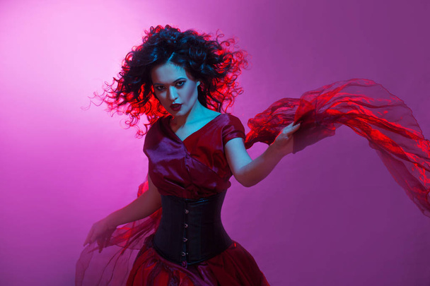 Femme fatale dancing, portrait in Studio with bright toning, blue and red color. - Foto, afbeelding