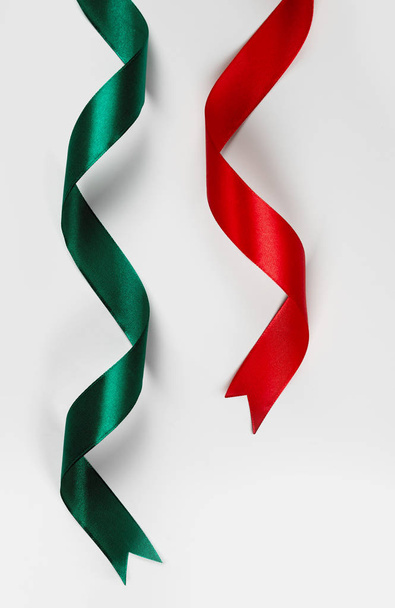 Красная и зеленая атласная лента на белом фоне
 - Фото, изображение