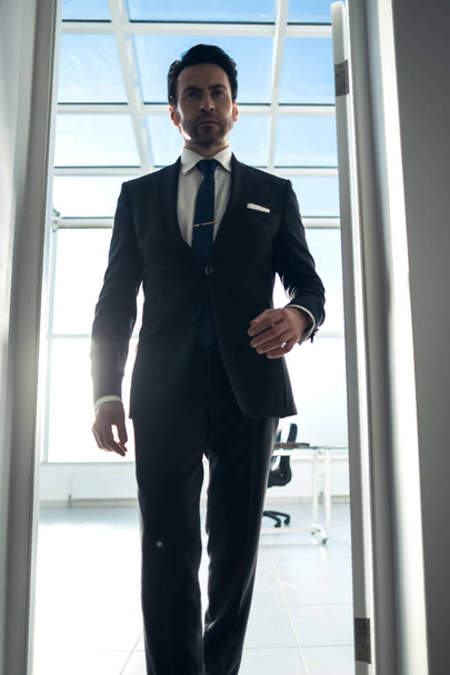 serious businessman walking down the office hallway - Photo, Image