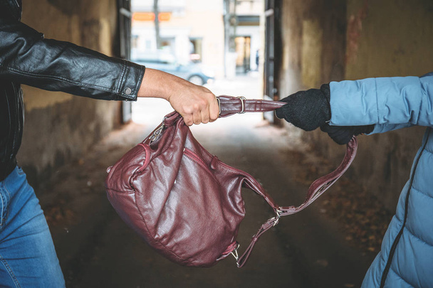 Ληστής τσάντα αποσπασματικά από τα χέρια γυναίκας, κοντινό πλάνο. Εγκληματική λωποδύτης και εγκλήματα σε δρόμο της πόλης - Φωτογραφία, εικόνα
