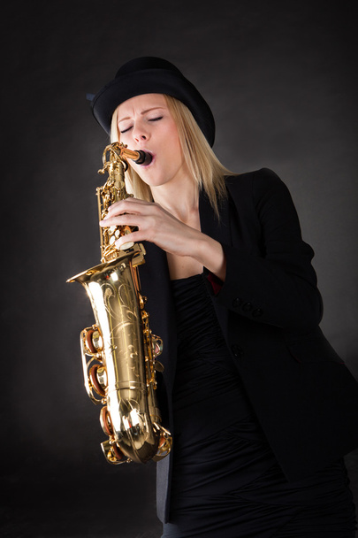 Beautiful young woman playing saxophone - Photo, Image