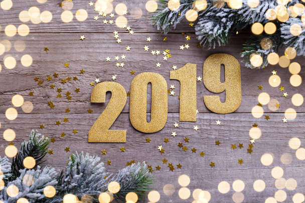 Happy New Year 2019 golden decoration and numbers on natural barn wood background greeting card template - Foto, imagen