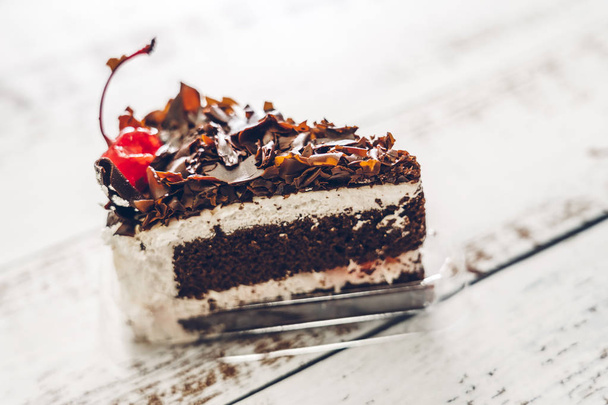 Delicious chocolate cake slice on white wooden table - Zdjęcie, obraz