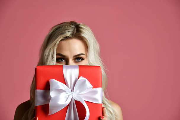 Beautiful woman hold red Christmas presents gift box for new year celebration  - Photo, Image