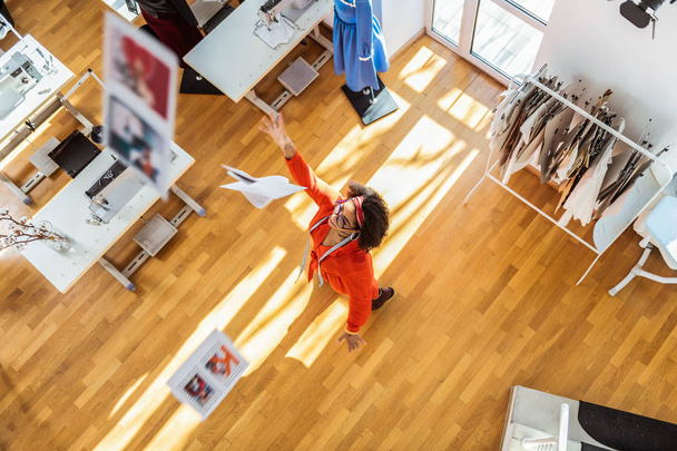 Active amused lady in red dress having fun in her studio - Zdjęcie, obraz