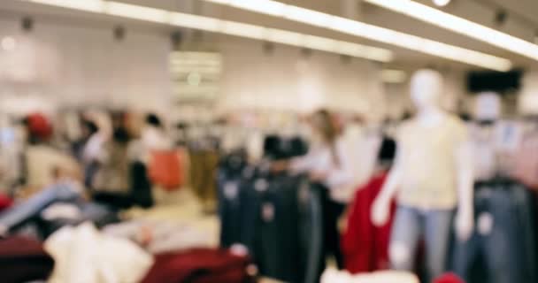 Blured Bokeh View of Clothes On Shelves and Hanger Στο κατάστημα του εμπορικού κέντρου - Πλάνα, βίντεο