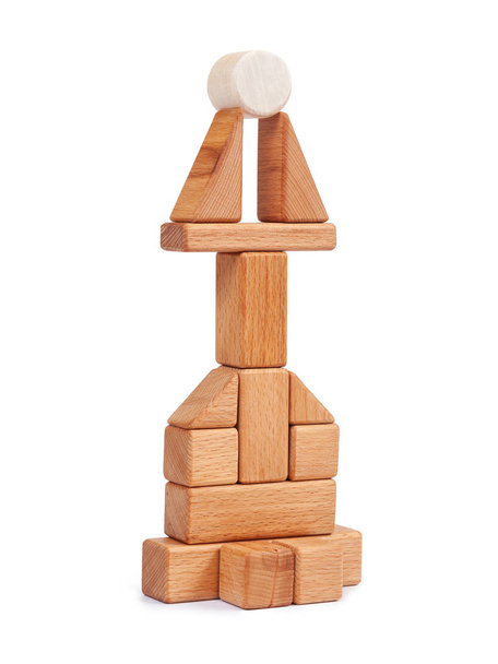 Photo wooden constructor of small cubes, triangles, balls and other forms of beech on a white isolated background. Wooden constructor, folded in the form of a tower - Photo, Image