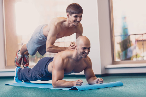 Homens felizes realizam exercícios físicos difíceis
. - Foto, Imagem