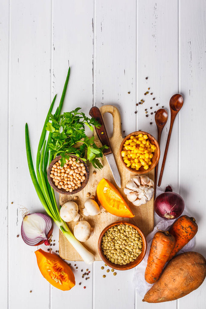 Ingrediënten voor plantaardig veganistische soep met linzen, champignons en kikkererwten op een witte houten achtergrond, top uitzicht. - Foto, afbeelding