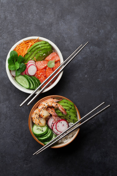 Poke bowl with salmon, shrimps and vegetables. Traditional Hawaiian raw fish salad. Top view with copy space - 写真・画像