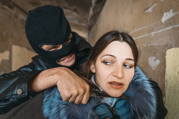 Masked robber man put knife to female victim's throat - Foto, Imagen