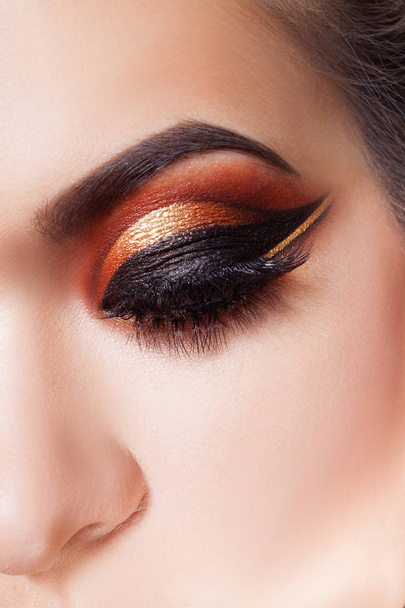 Amazing Bright eye makeup with a wide arrow. Brown and gold tones, colored eyeshadow - Fotografie, Obrázek