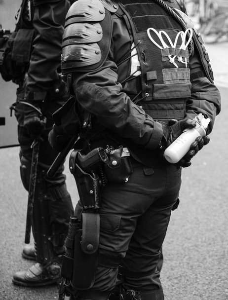 Поліцейський тримає сльозогінний газ готовий використовувати його на мітингу в о.
 - Фото, зображення