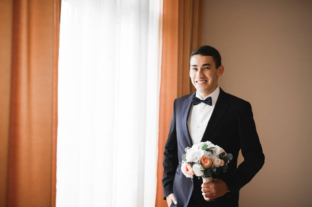 Grooms morning preparation. Handsome man getting dressed and preparing for the wedding. - Photo, image