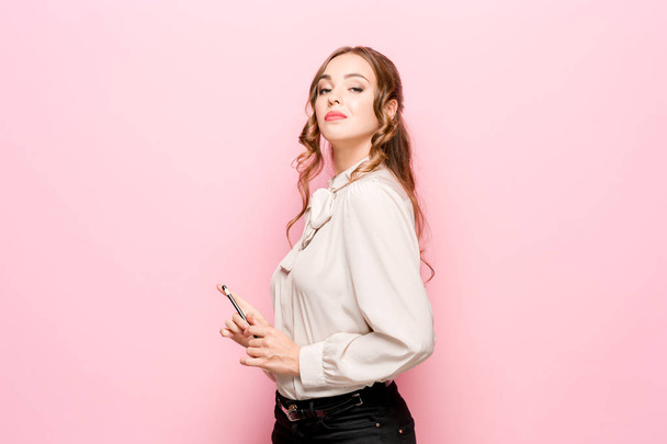 La giovane donna d'affari frustrata seria bella su sfondo rosa
 - Foto, immagini