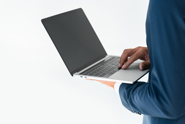 cropped image of businessman using laptop with blank screen isolated on white - Fotó, kép