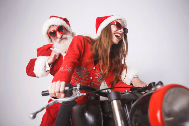 Santa claus und junge mrs. claus beim Motorradfahren - Foto, Bild