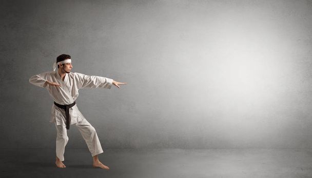 Small karate man fighting in an empty space - Foto, imagen