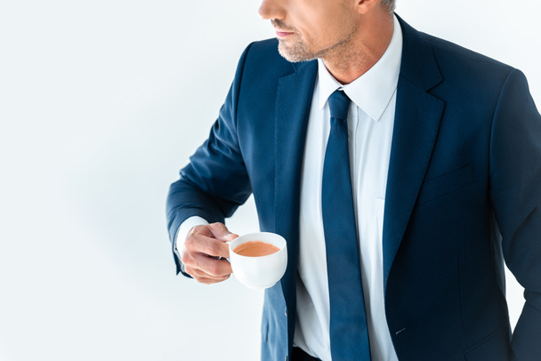 cropped image of businessman holding cup of coffee isolated on white - Фото, изображение