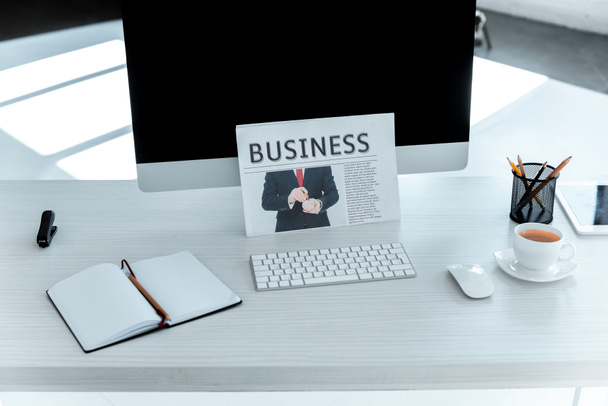бизнес-газета, ноутбук и компьютер на столе в офисе
 - Фото, изображение