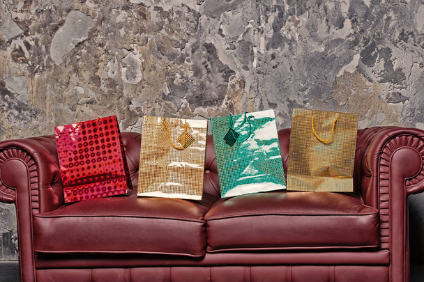 Présentez les sacs sur le canapé sur fond de mur de ciment gris
 - Photo, image