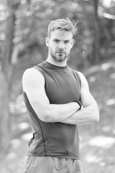 Sportsman with arms crossed in summer park. Strong man ready for training on fresh air. Fit and confident macho. Sport and workout activity. Relax in forest or park. Wellness and bodycare - Foto, imagen