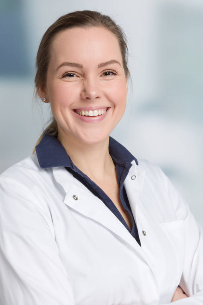 jonge lachende vrouwelijke arts in arts is algemeen met de stethoscoop - Foto, afbeelding