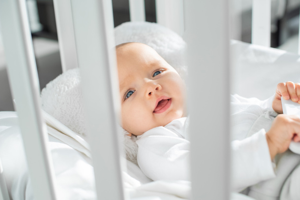 criança infantil feliz deitado no berço do bebê branco
  - Foto, Imagem