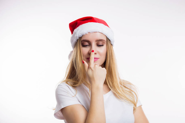 Beautiful funny blonde woman wearing red Santa hat smiling and finger pointing at her nose on white background. Christmas, new year and celebration concept - Fotoğraf, Görsel