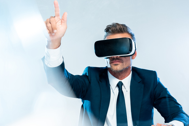 zakenman in virtual reality headset aan iets te raken geïsoleerd op wit, kunstmatige intelligentie concept - Foto, afbeelding