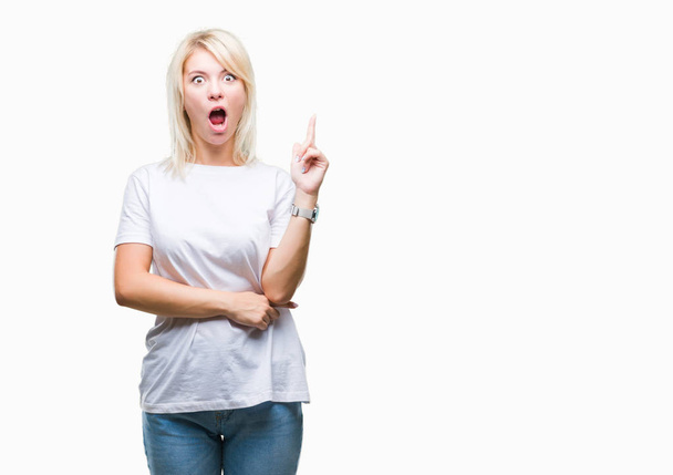 Young beautiful blonde woman wearing white t-shirt over isolated background pointing finger up with successful idea. Exited and happy. Number one. - Fotoğraf, Görsel
